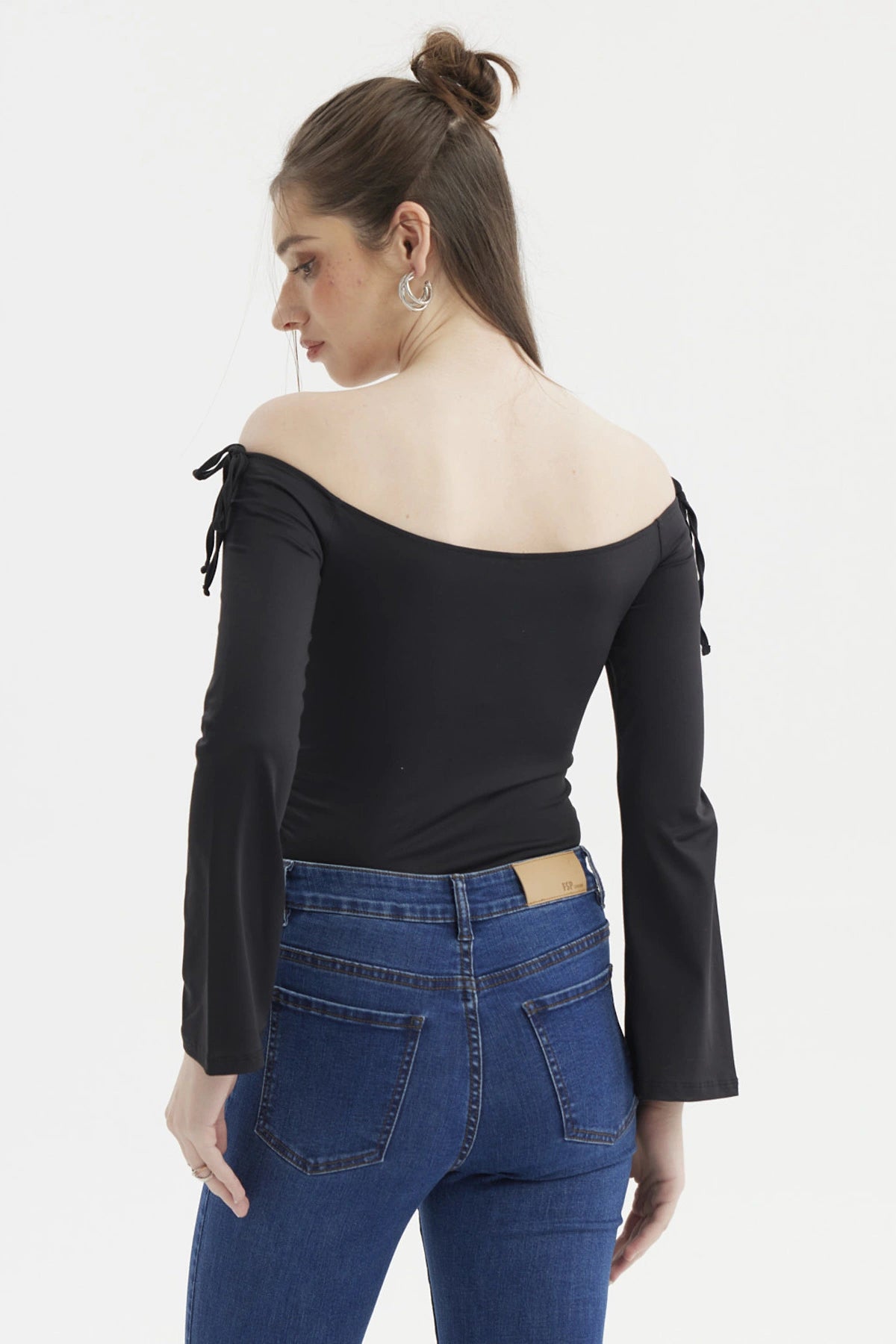 Polera negra de mujer con diseño Bardot hombros descubiertos y lazos en las mangas ajustadas