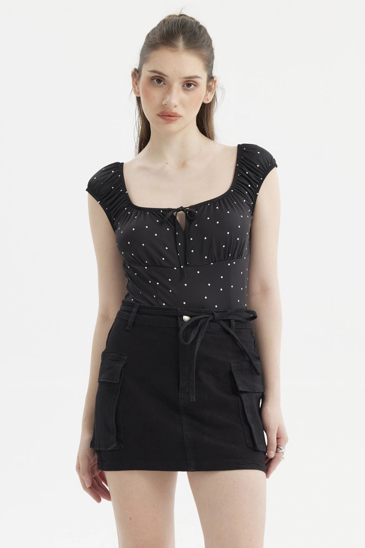 Polera negra de mujer con escote Bardot y diseño de lunares blancos pequeños estilo casual elegante