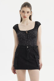 Polera negra de mujer con escote Bardot y diseño de lunares blancos pequeños estilo casual elegante