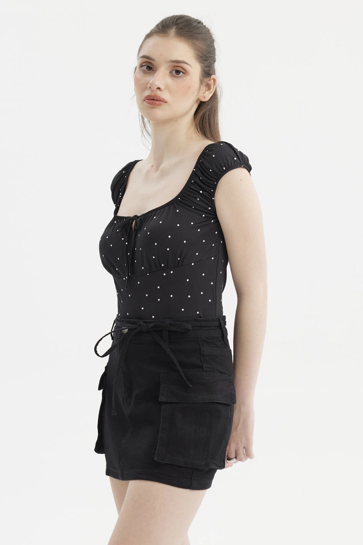 Polera negra de mujer con escote Bardot y diseño de lunares blancos pequeños estilo casual elegante