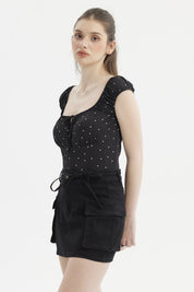Polera negra de mujer con escote Bardot y diseño de lunares blancos pequeños estilo casual elegante