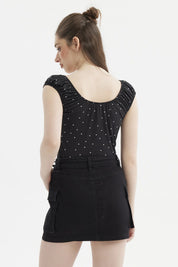 Polera negra de mujer con escote Bardot y diseño de lunares blancos pequeños estilo casual elegante