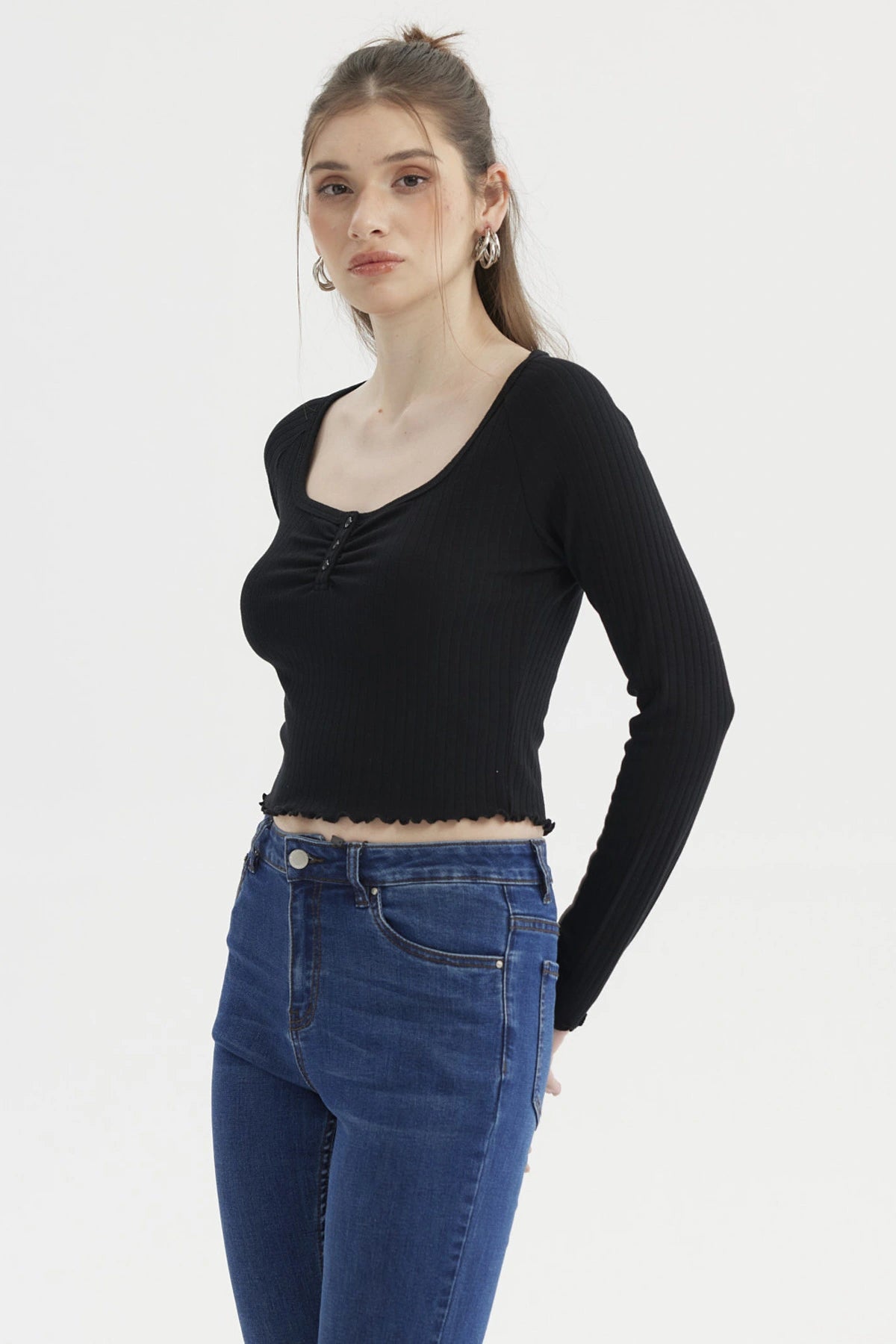 Polera negra de manga larga con escote abotonado y borde ondulado prenda lisa ajustada