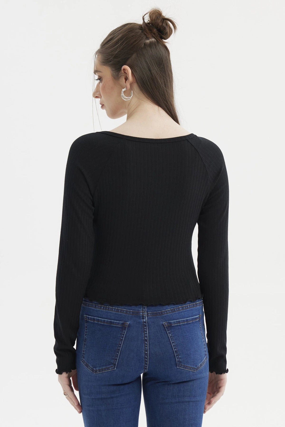Polera negra de manga larga con escote abotonado y borde ondulado prenda lisa ajustada