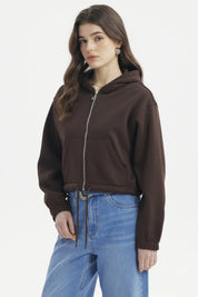 Polerón mujer café oscuro estilo crop con cierre delantero y capucha diseño liso perfecto para un look casual moderno