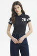 Polera negra de mujer con cuello polo y botones estampada con número 78 en el pecho y líneas blancas en mangas
