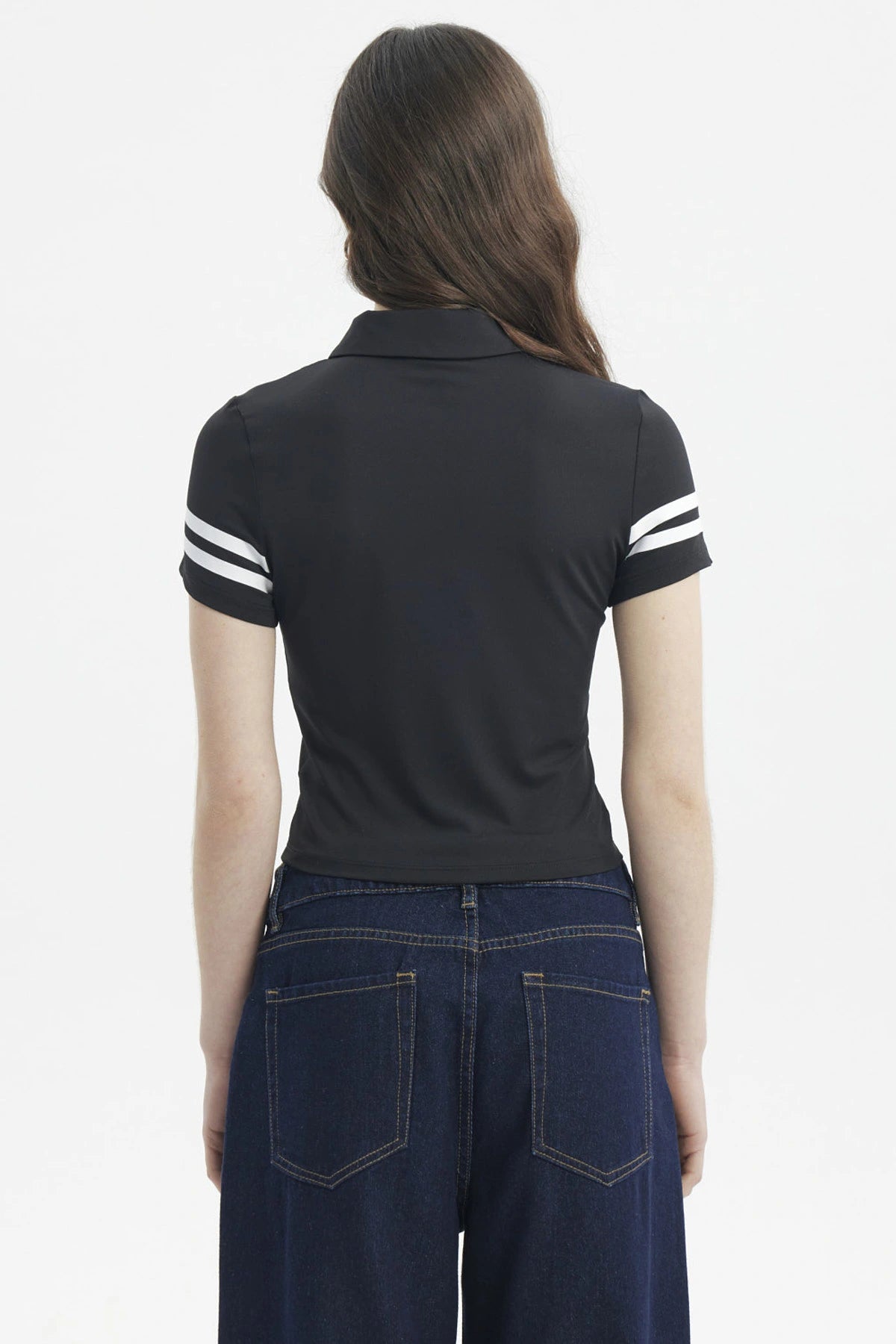 Polera negra de mujer con cuello polo y botones estampada con número 78 en el pecho y líneas blancas en mangas