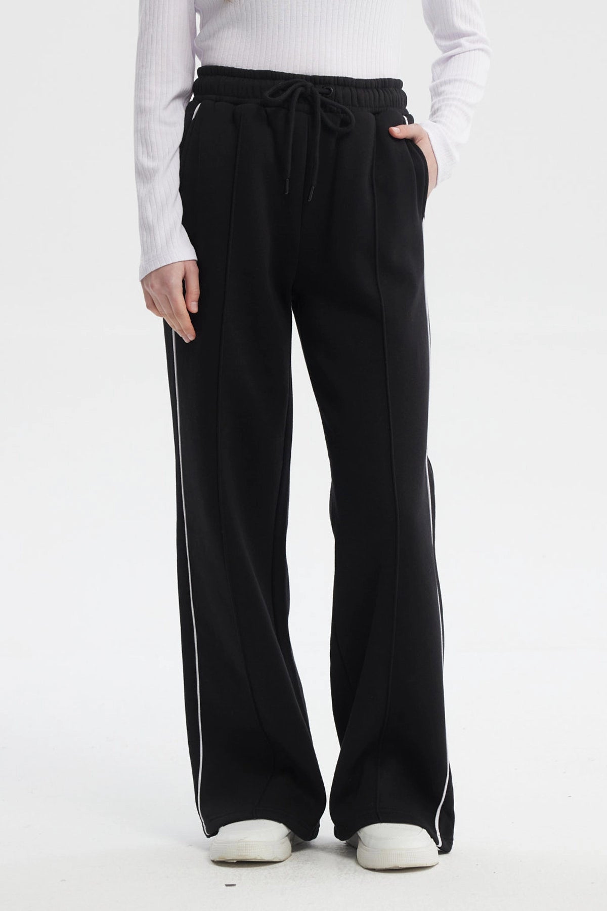Pantalón buzo negro de mujer tipo wide leg con líneas blancas laterales y cintura elástica sin estampa lisa