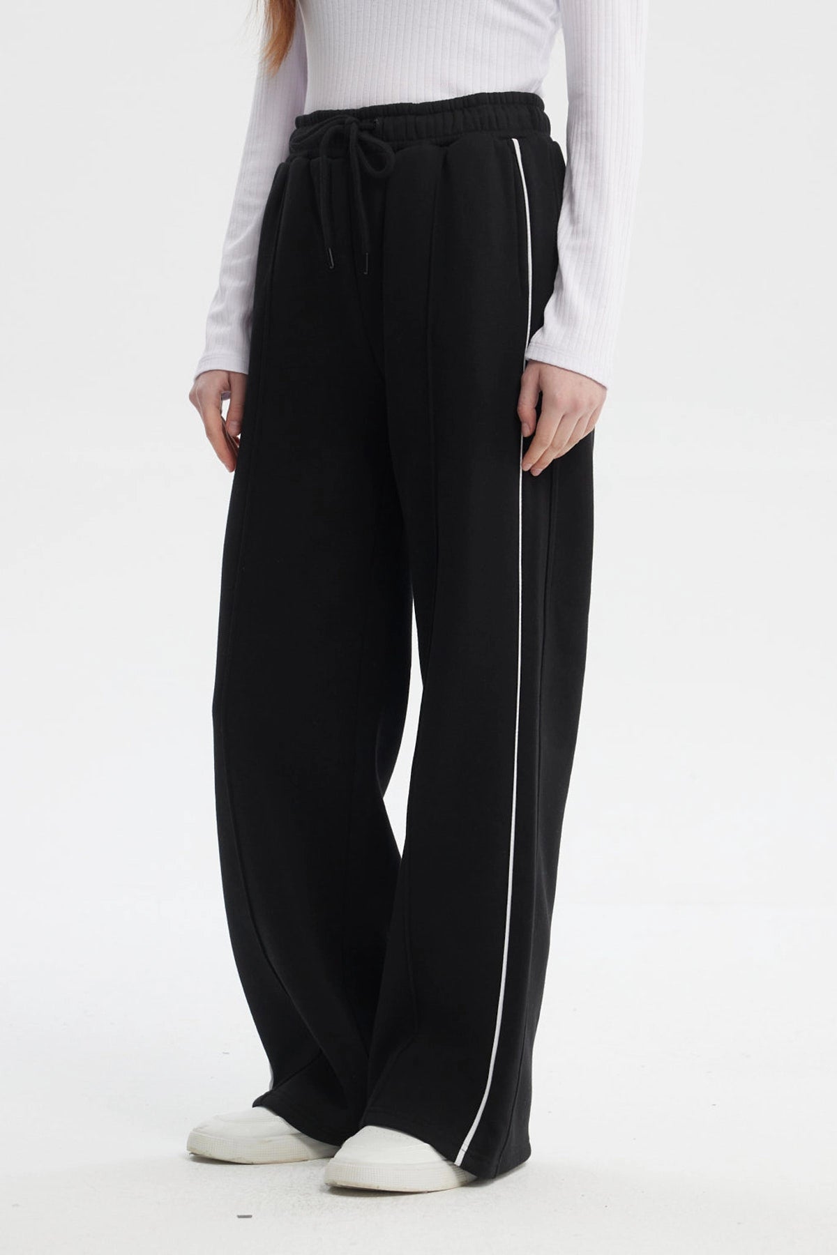 Pantalón buzo negro de mujer tipo wide leg con líneas blancas laterales y cintura elástica sin estampa lisa