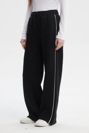 Pantalón buzo negro de mujer tipo wide leg con líneas blancas laterales y cintura elástica sin estampa lisa