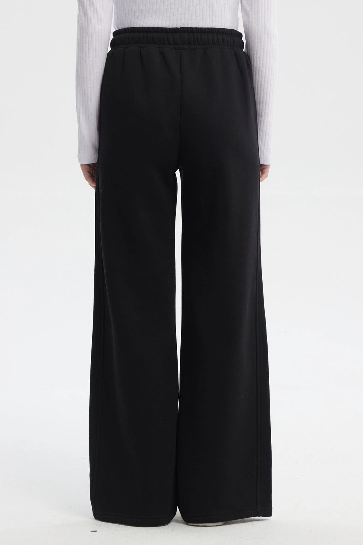 Pantalón buzo negro de mujer tipo wide leg con líneas blancas laterales y cintura elástica sin estampa lisa
