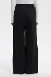 Pantalón buzo negro de mujer tipo wide leg con líneas blancas laterales y cintura elástica sin estampa lisa