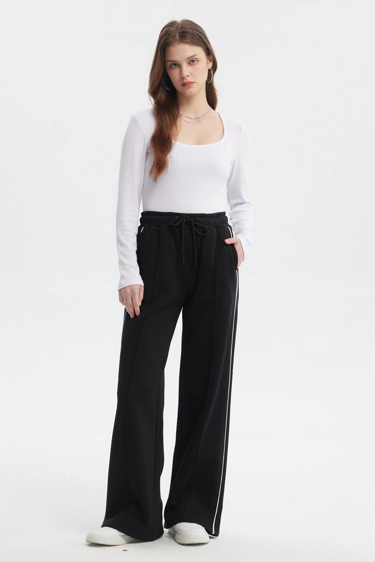 Pantalón buzo negro de mujer tipo wide leg con líneas blancas laterales y cintura elástica sin estampa lisa