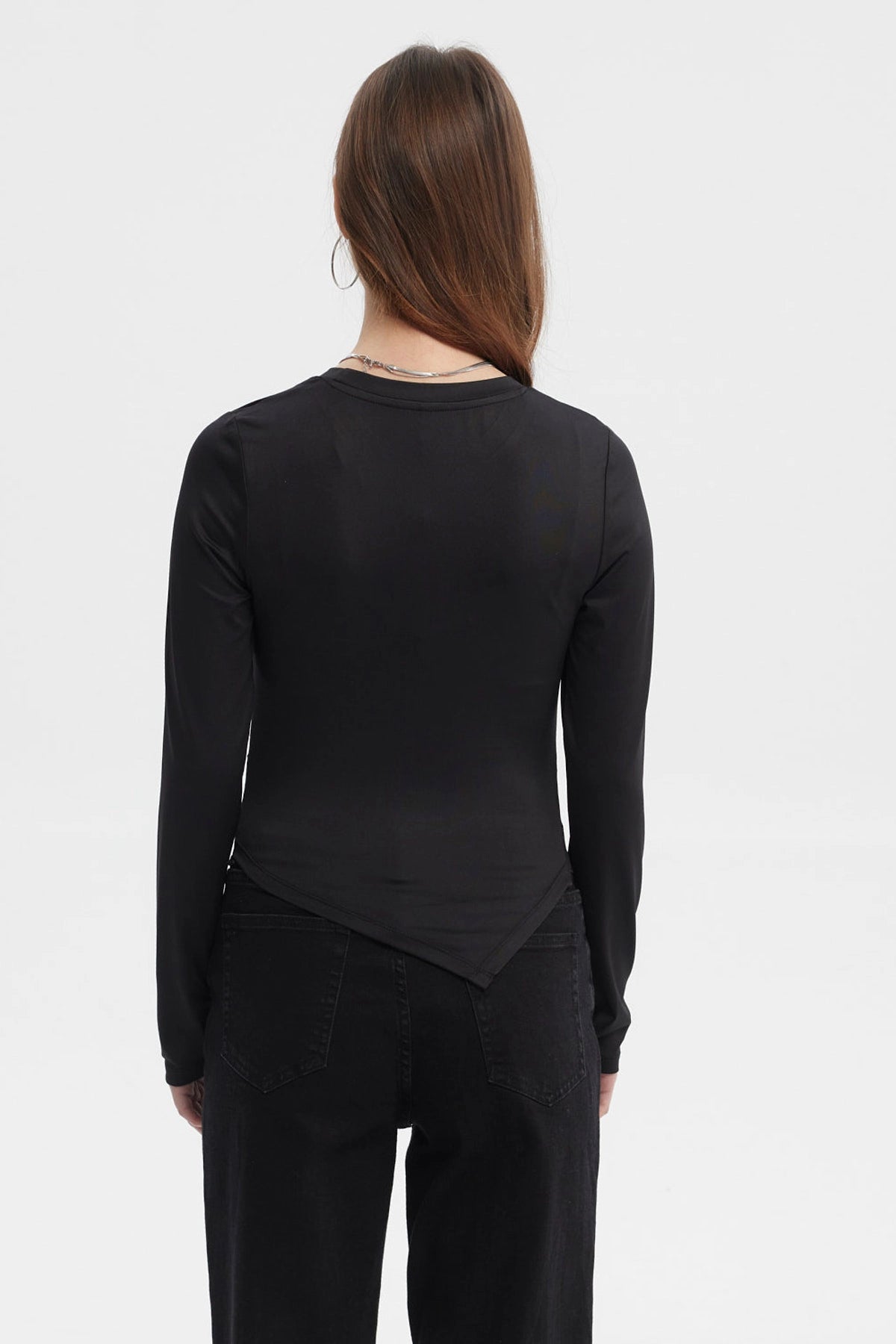Polera mujer negra manga larga con basta en punta diseño liso ajuste suave al cuerpo sin estampado visible
