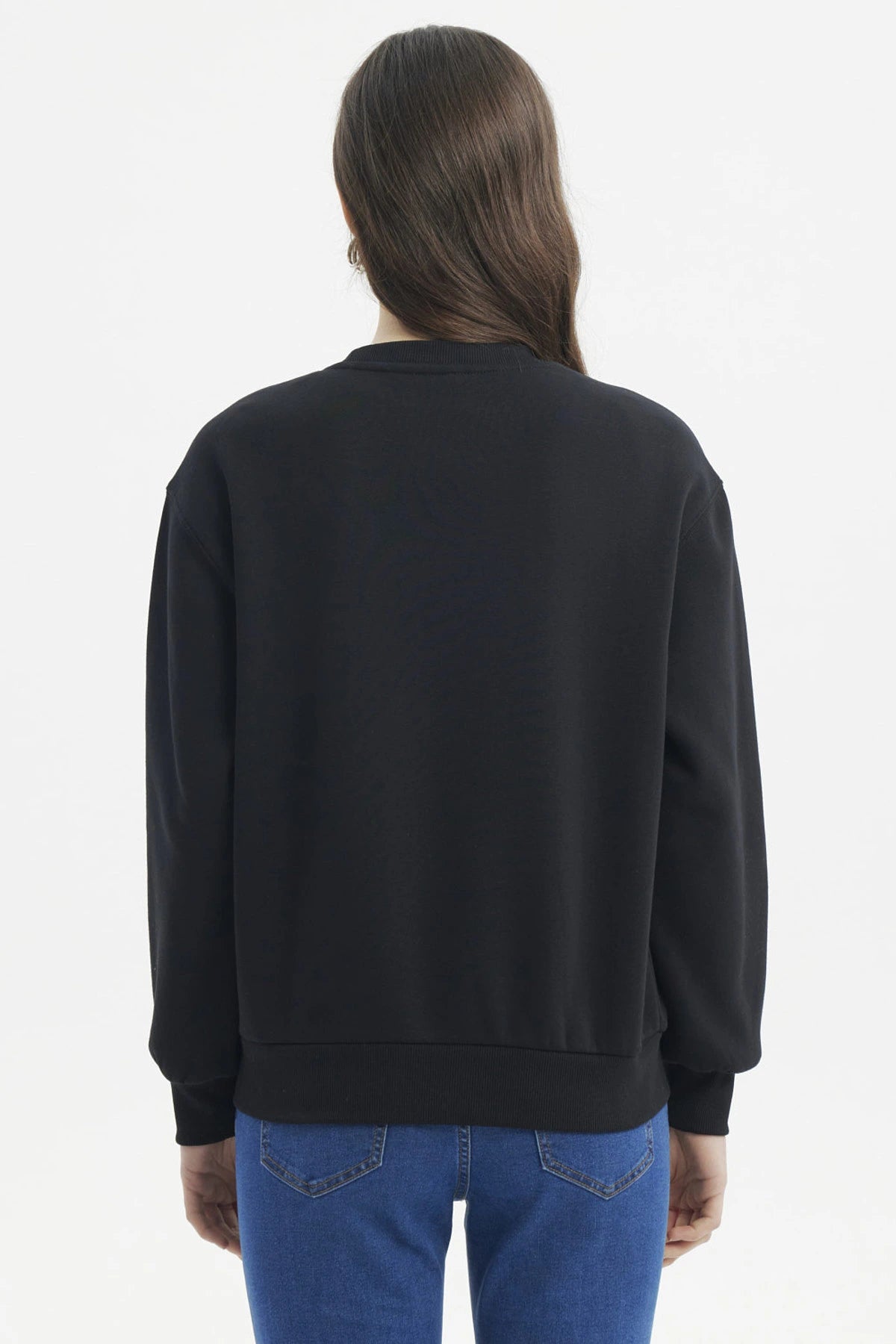 Polerón negro liso mujer diseño minimalista detalle bordado pecho ajuste relajado ideal para estilo casual