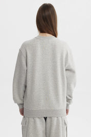 Polerón mujer liso gris melange claro de corte relajado y cuello redondo sin estampa ideal para días casuales