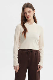 Polera de mujer color crema con cuello redondo y mangas largas prenda lisa ajustada al cuerpo estilo casual