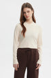 Polera de mujer color crema con cuello redondo y mangas largas prenda lisa ajustada al cuerpo estilo casual