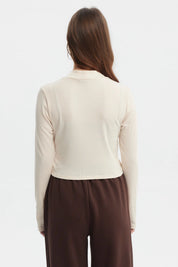 Polera de mujer color crema con cuello redondo y mangas largas prenda lisa ajustada al cuerpo estilo casual