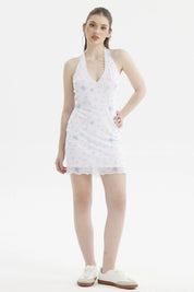 Vestido corto blanco con estampado azul de palmeras y flores pequeñas en estilo tropical a lo largo del vestido