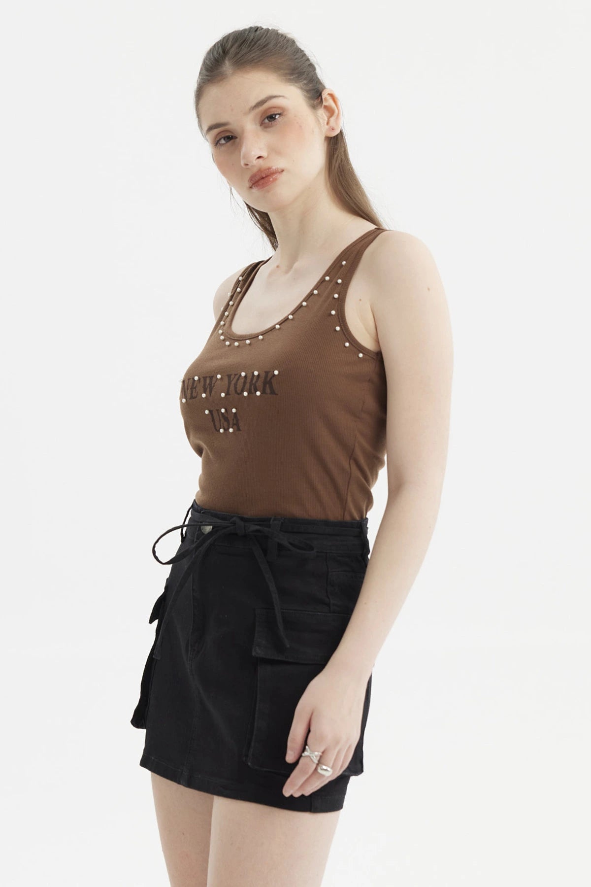 Polera café oscuro para mujer con ribetes y rivets en los hombros estampado frontal New York USA estilo casual urbano