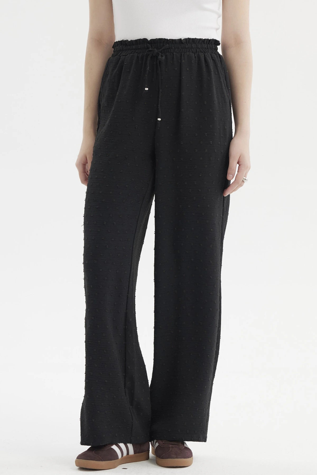 Pantalón negro de mujer con textura plumeti y pretina elasticada sin estampa visible