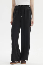 Pantalón negro de mujer con textura plumeti y pretina elasticada sin estampa visible