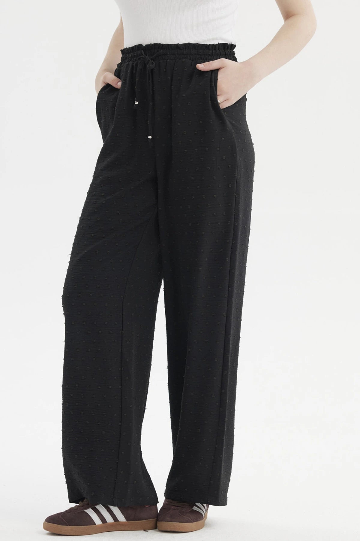Pantalón negro de mujer con textura plumeti y pretina elasticada sin estampa visible