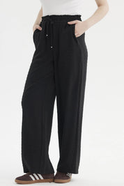 Pantalón negro de mujer con textura plumeti y pretina elasticada sin estampa visible