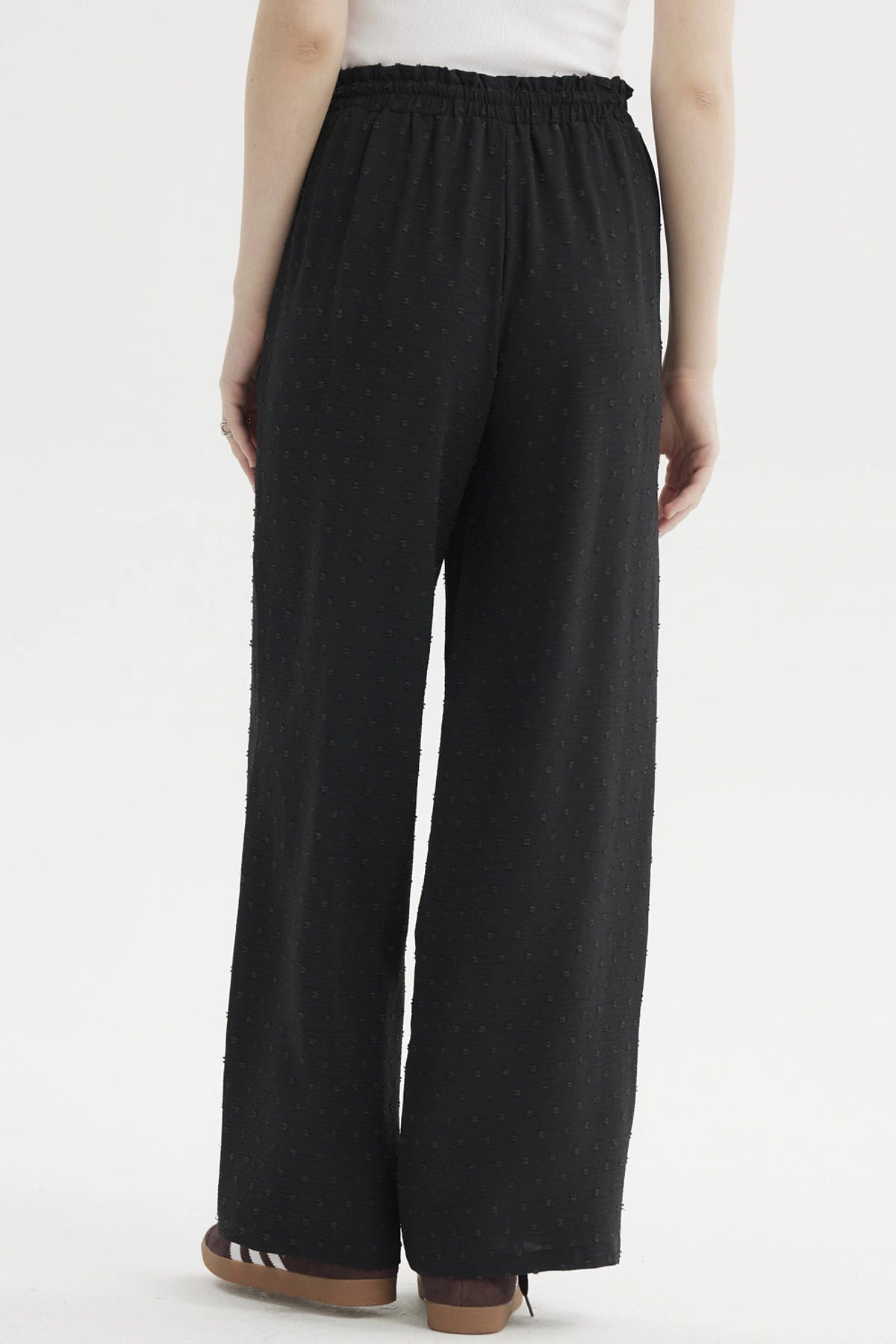 Pantalón negro de mujer con textura plumeti y pretina elasticada sin estampa visible