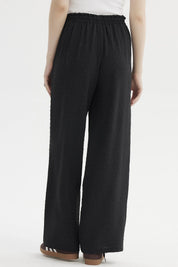 Pantalón negro de mujer con textura plumeti y pretina elasticada sin estampa visible