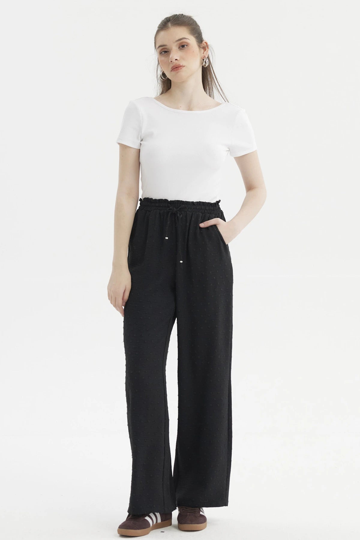 Pantalón negro de mujer con textura plumeti y pretina elasticada sin estampa visible