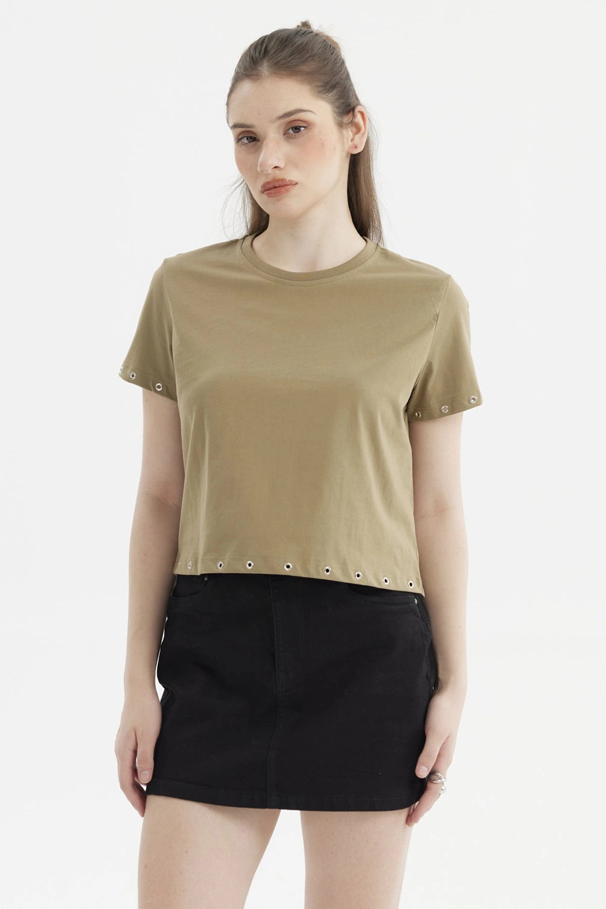 Polera mujer verde musgo con ojales metálicos en mangas y dobladillo estilo casual y moderno sin estampa visible