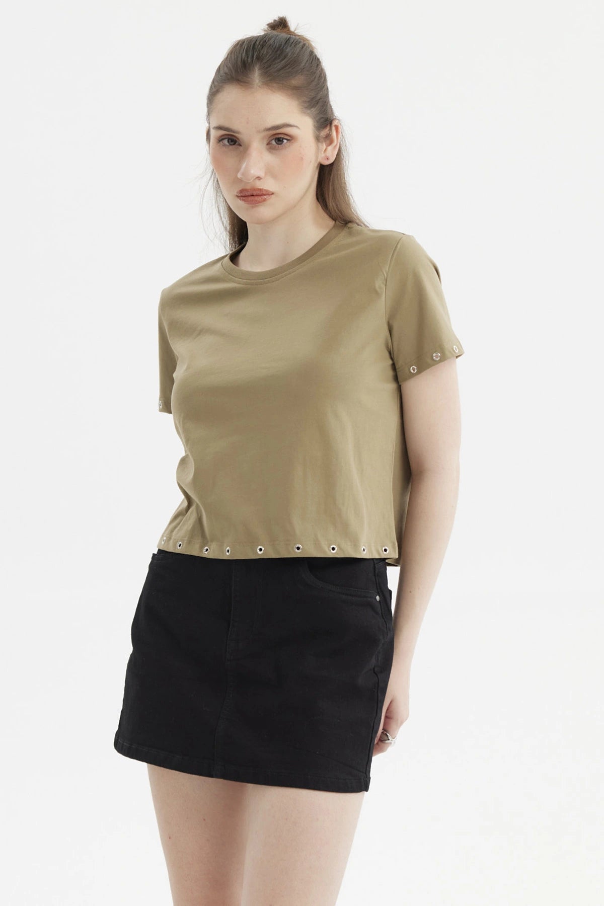 Polera mujer verde musgo con ojales metálicos en mangas y dobladillo estilo casual y moderno sin estampa visible