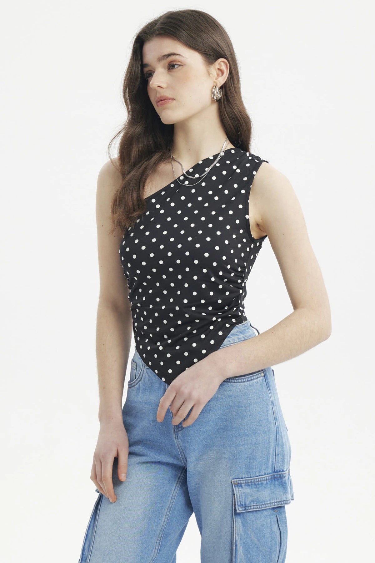 Polera asimétrica negra con lunares blancos pequeños estilo casual sin mangas ajuste al cuerpo