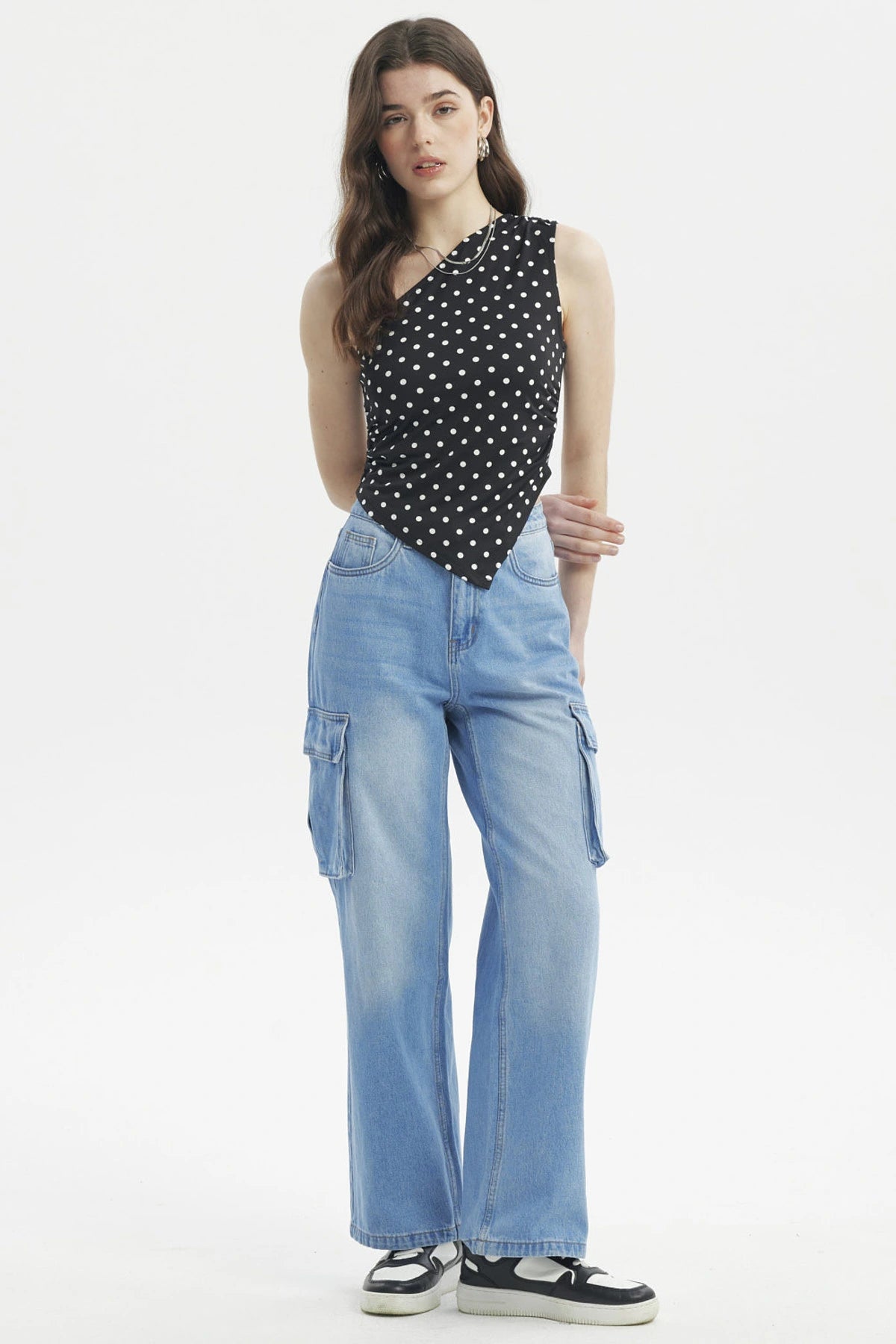 Polera asimétrica negra con lunares blancos pequeños estilo casual sin mangas ajuste al cuerpo