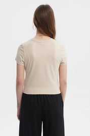 Polera ajustada beige oscuro con texto BEST WISH en el pecho en letras brillantes estilo minimalista sin estampa adicional