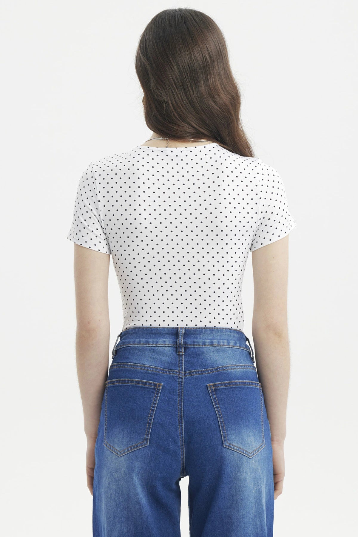 Polera ajustada blanca con puntos negros estilo minimalista sin estampa visible