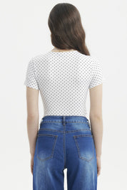 Polera ajustada blanca con puntos negros estilo minimalista sin estampa visible