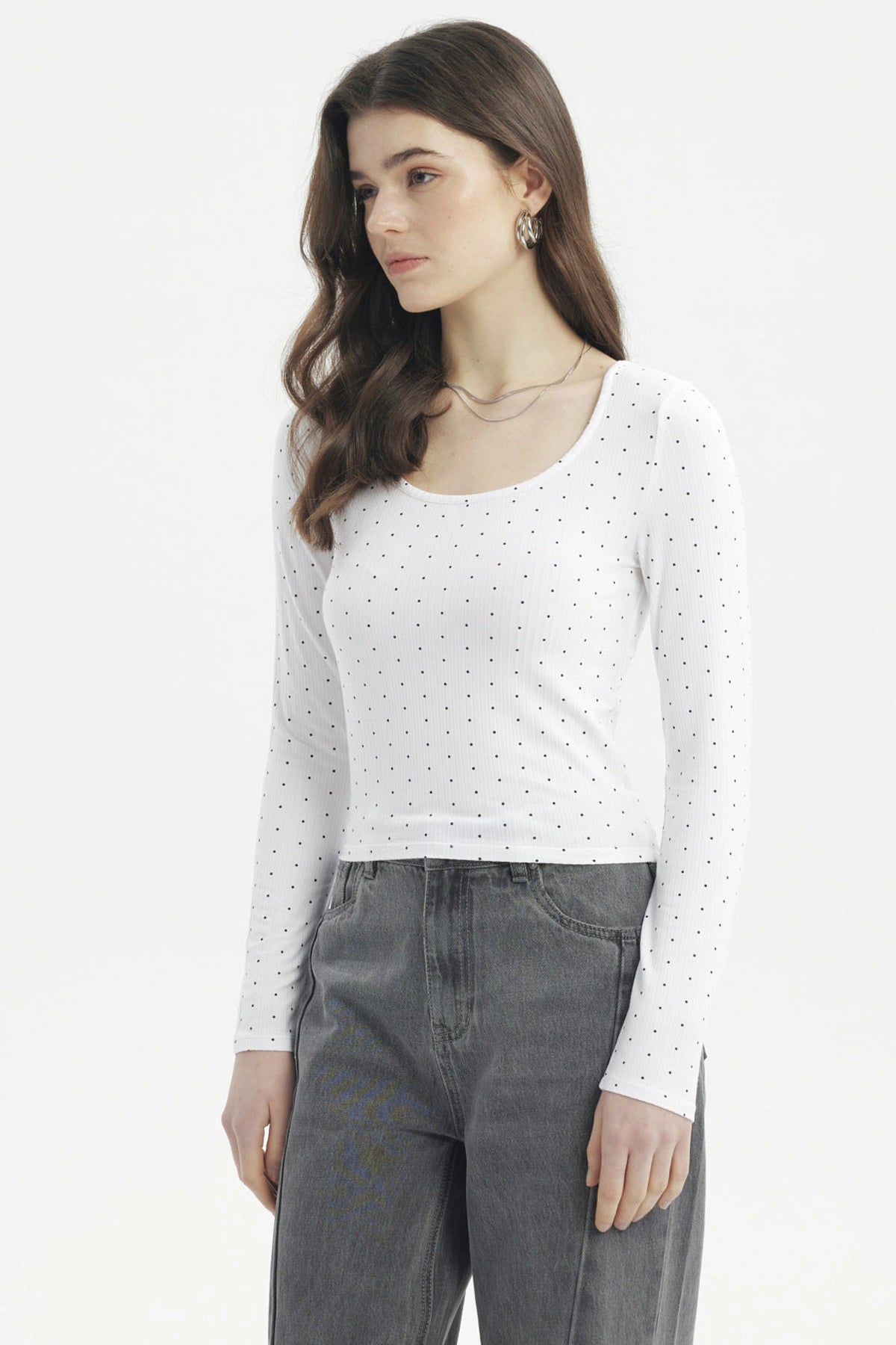 Polera blanca de mujer con cuello redondo y estampado de pequeños puntos negros lisa ajustada y de manga larga