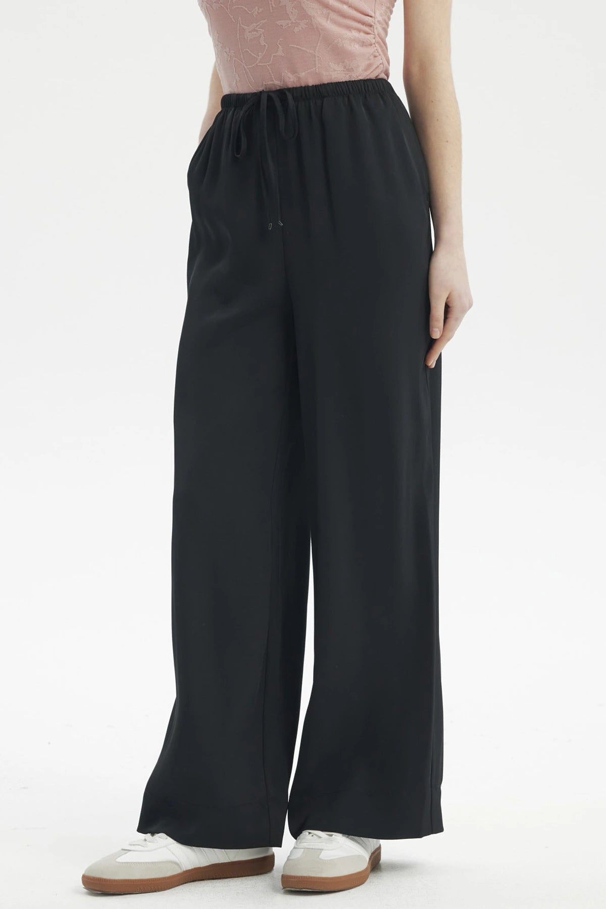 Pantalón holgado negro con cordón ajustable en la cintura diseño liso ideal para un look casual cómodo y moderno