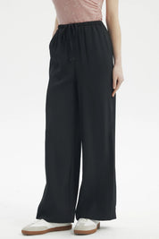 Pantalón holgado negro con cordón ajustable en la cintura diseño liso ideal para un look casual cómodo y moderno