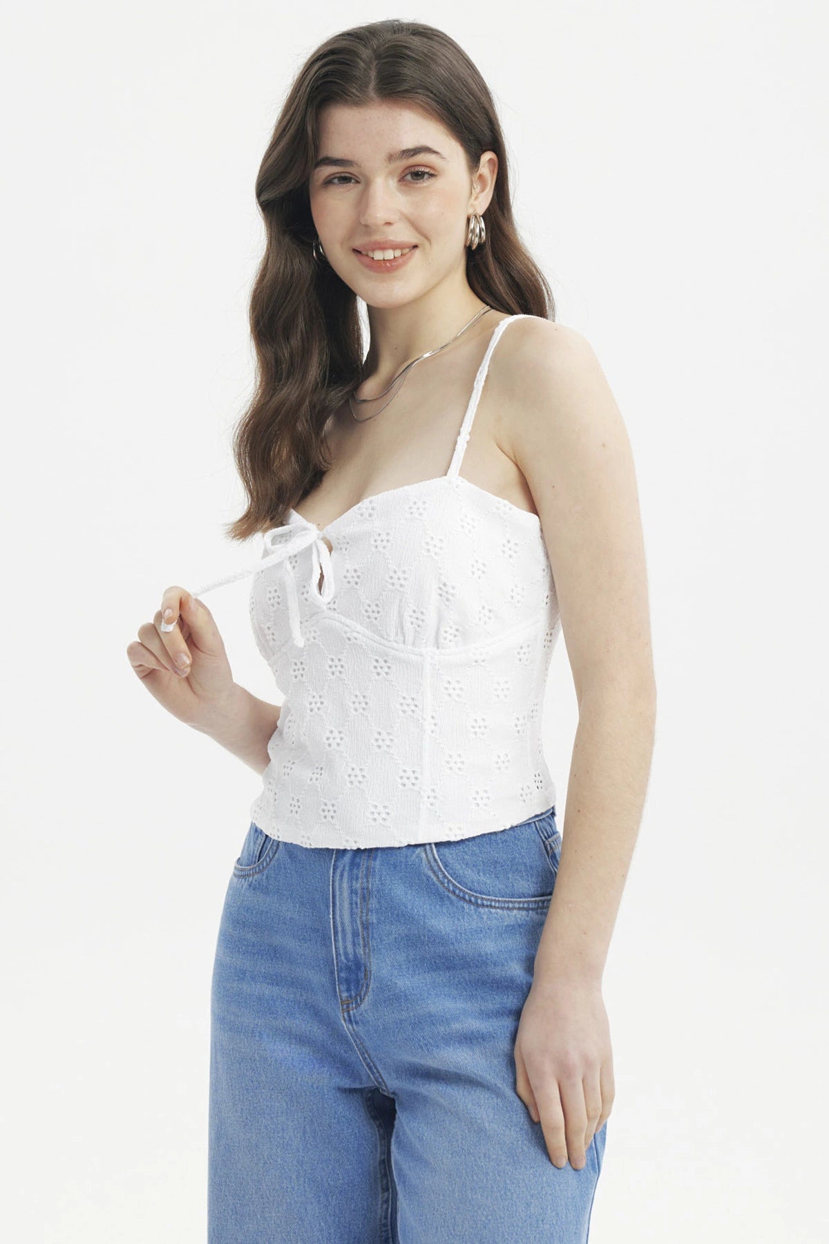 Polera de mujer blanca con tirantes y lazo en el escote con diseño floral calado ajustada y sin estampas