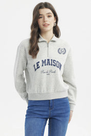 Polerón gris melange claro con cierre hasta el pecho diseño "LE MAISON Rue de Rivoli 1965" en el frente estilo casual