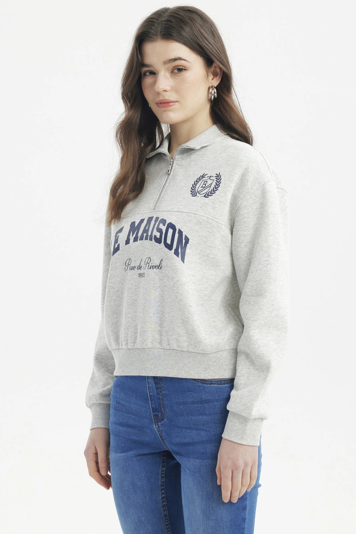 Polerón gris melange claro con cierre hasta el pecho diseño "LE MAISON Rue de Rivoli 1965" en el frente estilo casual