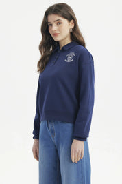Polerón mujer slim azul con cuello polo y botones delanteros diseño escudo y texto blanco en el pecho estilo casual