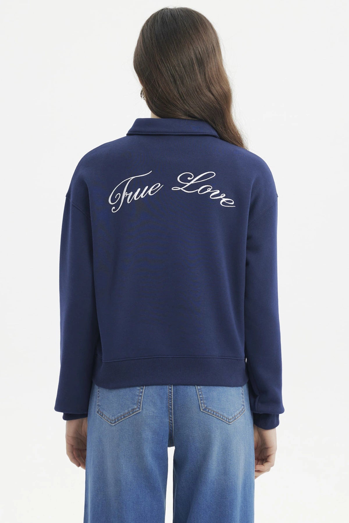 Polerón mujer slim azul con cuello polo y botones delanteros diseño escudo y texto blanco en el pecho estilo casual