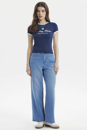 Polera ajustada azul con borde blanco y texto frontal Vitality Shine Vibrant Movement estilo casual moderno
