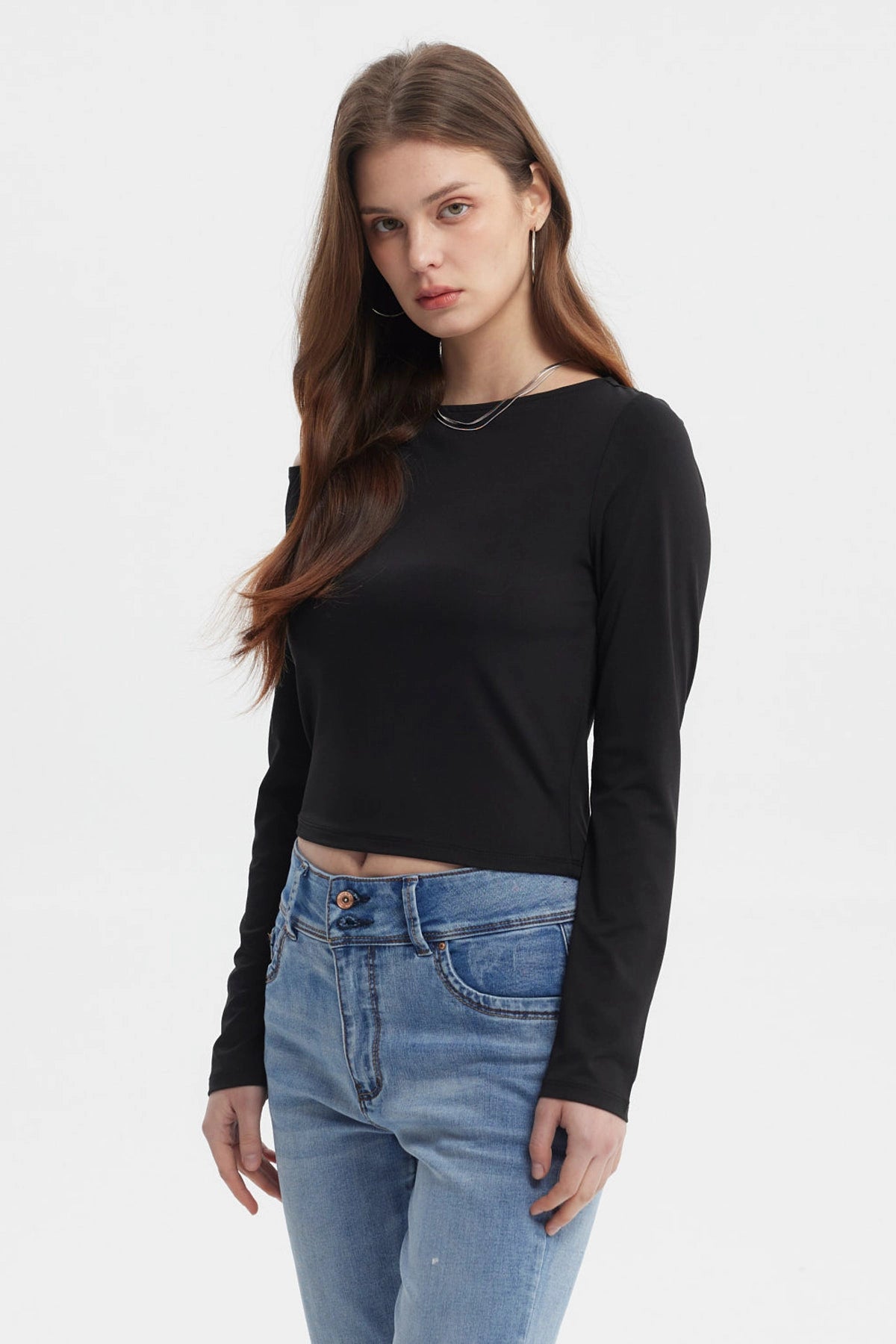 Polera negra de mujer con nudo en el hombro estilo minimalista manga larga sin estampa