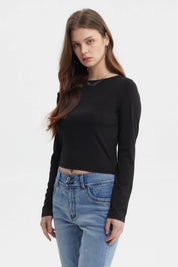 Polera negra de mujer con nudo en el hombro estilo minimalista manga larga sin estampa